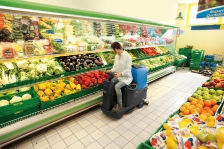 Поломоечная машина убирает торговый зал Поломоечная машина убирает торговый зал