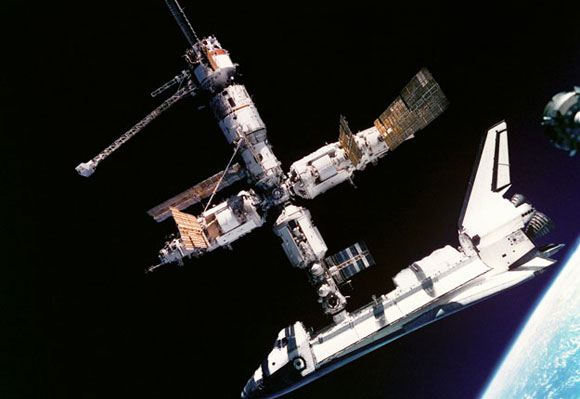 Станция «Мир» с пристыкованным к ней космическим челноком Станция «Мир» с пристыкованным к ней космическим челноком